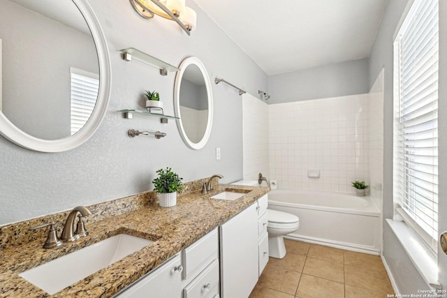 bathroom featuring vanity, toilet, a healthy amount of sunlight, and tile patterned flooring