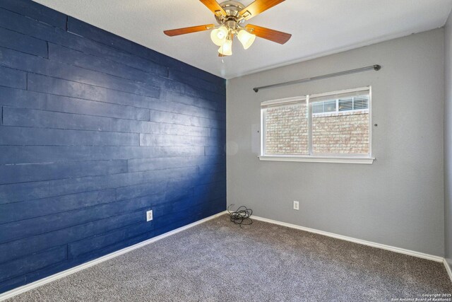 carpeted spare room with ceiling fan