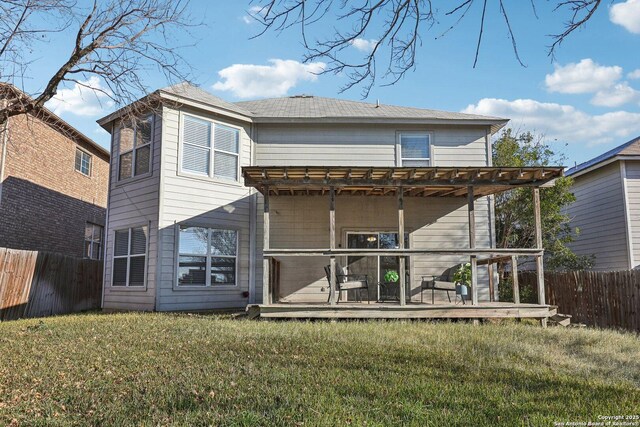 back of property with a lawn and a deck