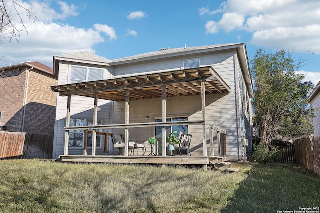 rear view of property with a wooden deck and a yard