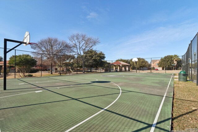 view of sport court with a playground and a gazebo