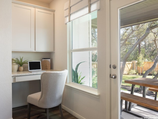 office featuring built in desk and dark hardwood / wood-style floors