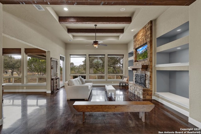 living room with a stone fireplace, built in features, a high ceiling, ceiling fan, and beam ceiling