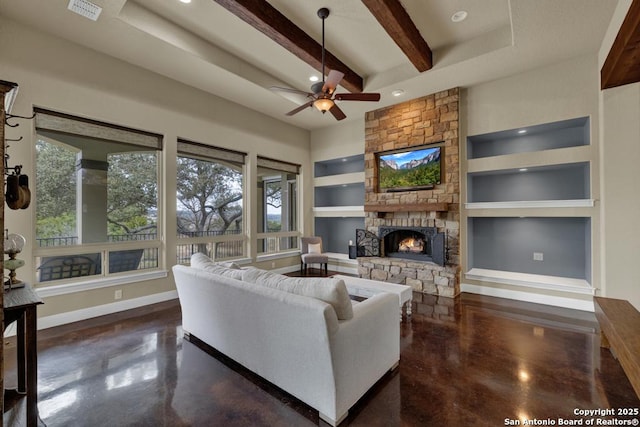 living room with beam ceiling, a stone fireplace, built in features, and ceiling fan