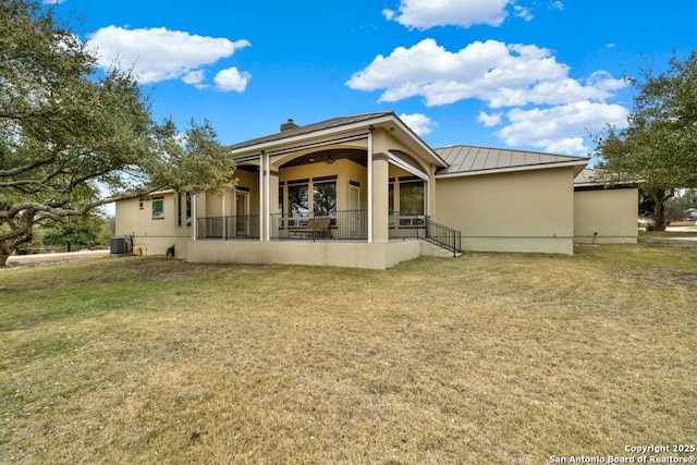 rear view of property with a yard and cooling unit