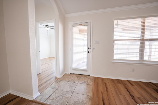 entryway featuring ceiling fan, a wealth of natural light, and ornamental molding