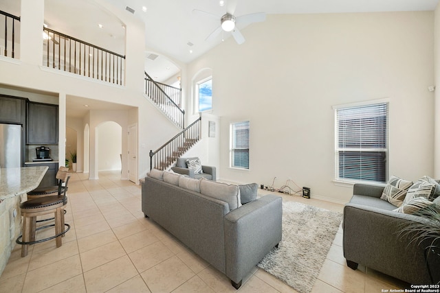 tiled living room with high vaulted ceiling and ceiling fan