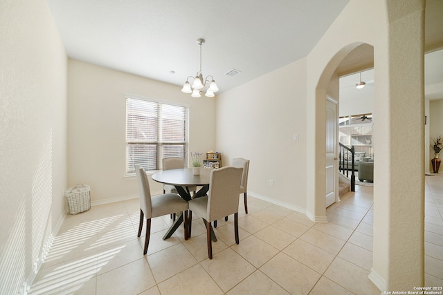 dining space featuring ceiling fan with notable chandelier and light tile patterned floors