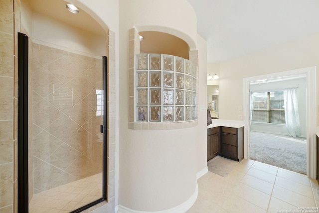 bathroom featuring tile patterned floors, walk in shower, and vanity