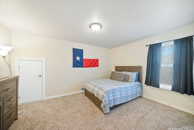 bedroom featuring light colored carpet and a textured ceiling