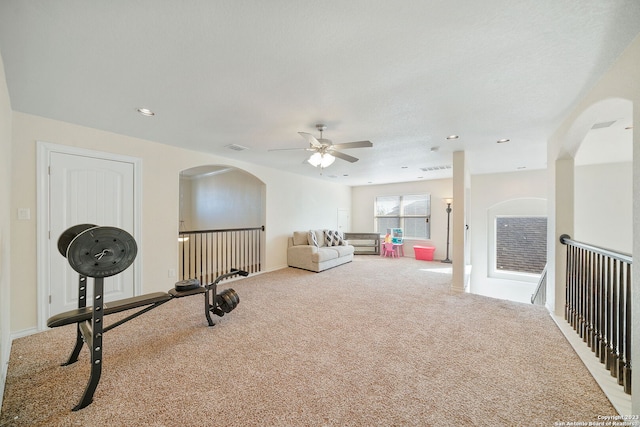 exercise room featuring ceiling fan and light carpet