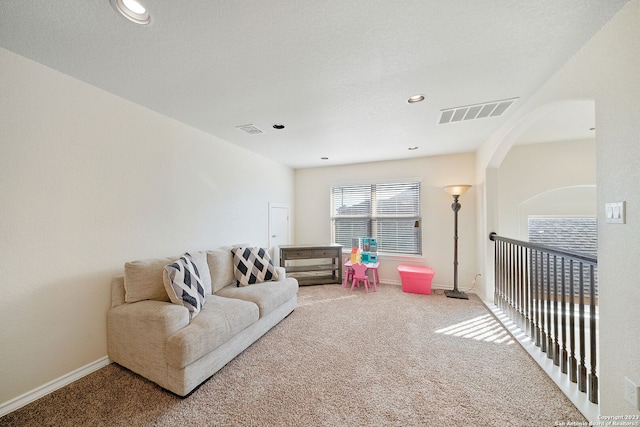 carpeted living room with a textured ceiling