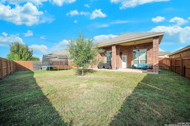 view of yard featuring a patio, outdoor lounge area, ceiling fan, and a trampoline