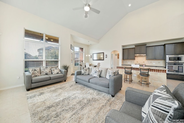 living room featuring ceiling fan, high vaulted ceiling, and light tile patterned floors