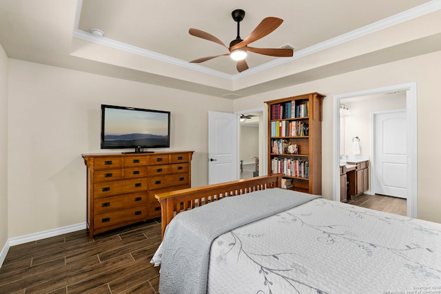 bedroom with a raised ceiling, ensuite bathroom, crown molding, and ceiling fan