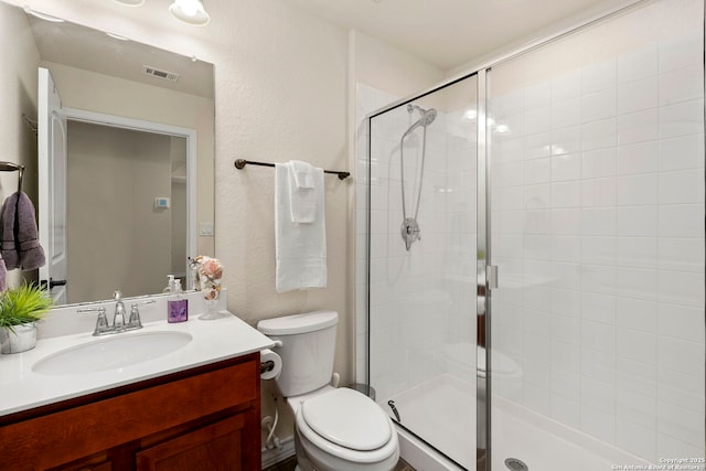 bathroom with toilet, vanity, and walk in shower