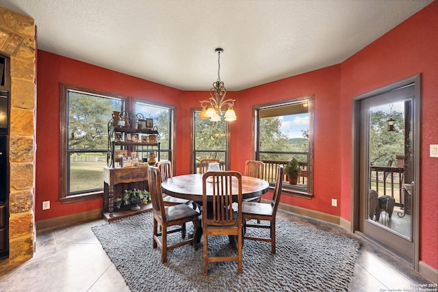 tiled dining room featuring an inviting chandelier and a textured ceiling