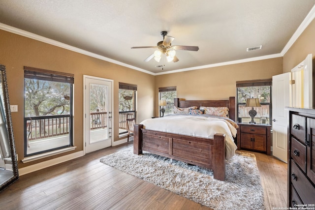 bedroom featuring access to exterior, ceiling fan, hardwood / wood-style floors, and multiple windows