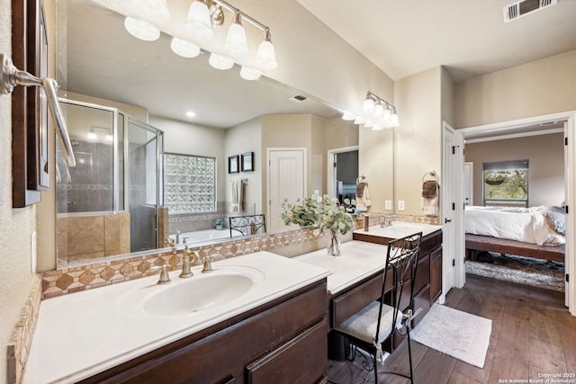 bathroom with wood-type flooring, vanity, and shower with separate bathtub