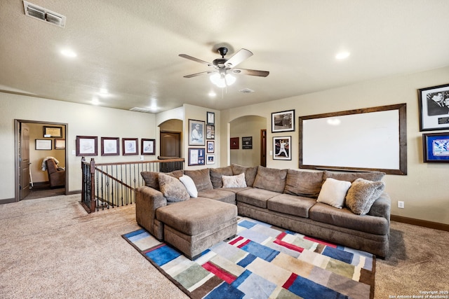 carpeted living room with ceiling fan and a textured ceiling