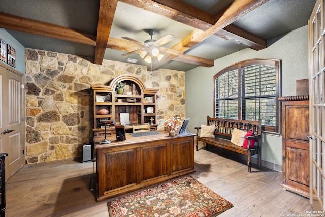 home office with light wood-type flooring, beamed ceiling, and ceiling fan