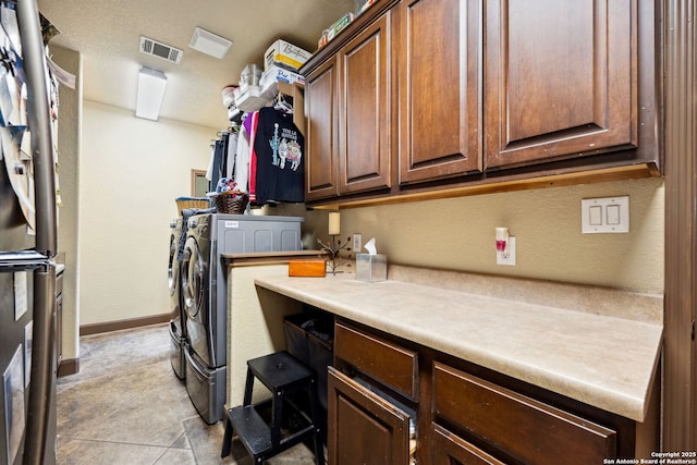 clothes washing area featuring cabinets and washer and clothes dryer