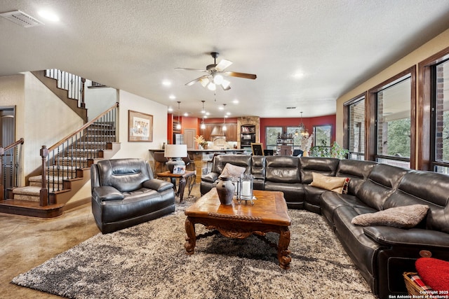 living room with a textured ceiling and ceiling fan