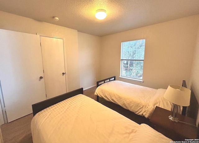 carpeted bedroom with a textured ceiling and a closet