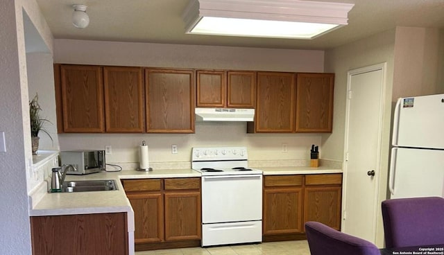 kitchen featuring sink, white appliances, and light tile patterned flooring