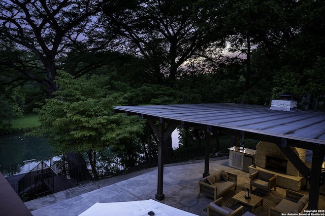 patio terrace at dusk featuring an outdoor living space with a fireplace