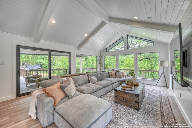 living room featuring vaulted ceiling with beams and light hardwood / wood-style floors