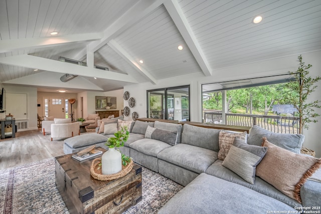 living room featuring lofted ceiling with beams, a healthy amount of sunlight, and hardwood / wood-style floors