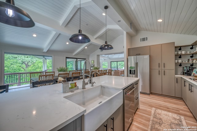 kitchen featuring pendant lighting, light stone counters, gray cabinets, and stainless steel appliances