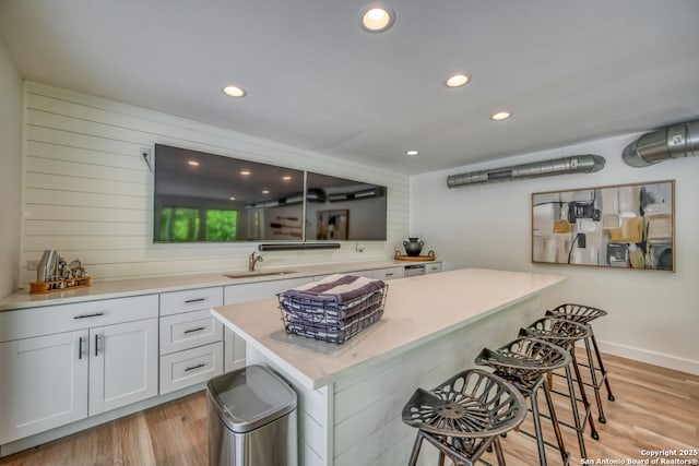 kitchen with sink, a breakfast bar area, kitchen peninsula, and white cabinets