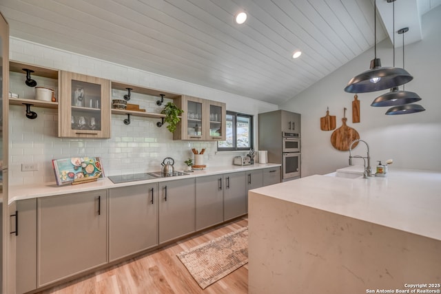 kitchen with pendant lighting, sink, backsplash, double oven, and black electric cooktop