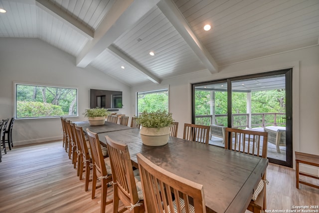 dining area featuring vaulted ceiling with beams and light wood-type flooring