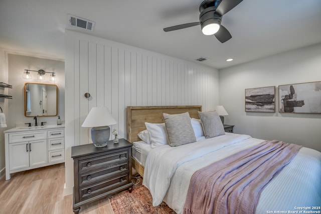 bedroom with sink, light hardwood / wood-style flooring, and ceiling fan