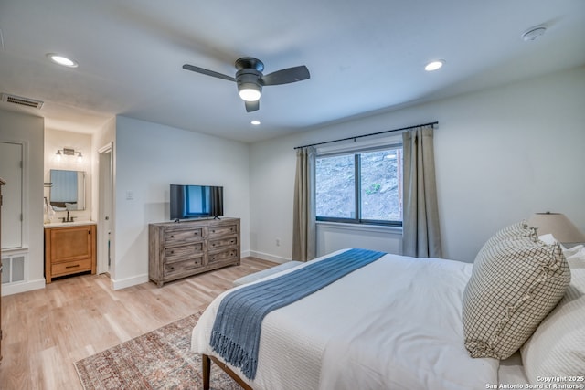 bedroom with ceiling fan, connected bathroom, sink, and light hardwood / wood-style flooring