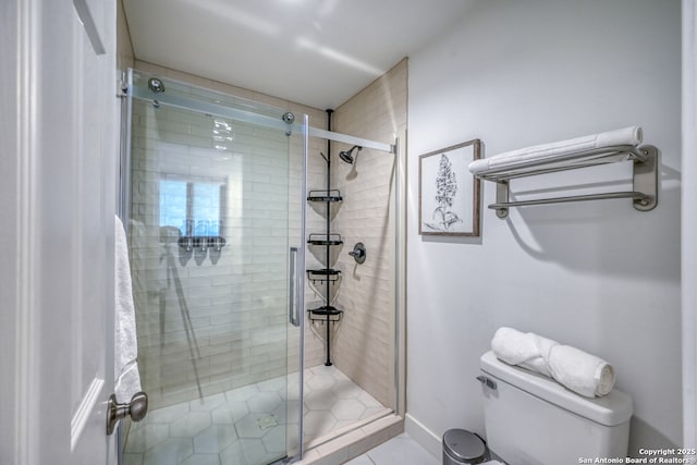 bathroom featuring a shower with door and toilet