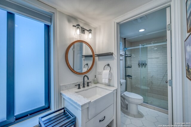 bathroom featuring toilet, vanity, tile patterned floors, and walk in shower