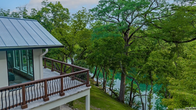 deck with a water view and a yard