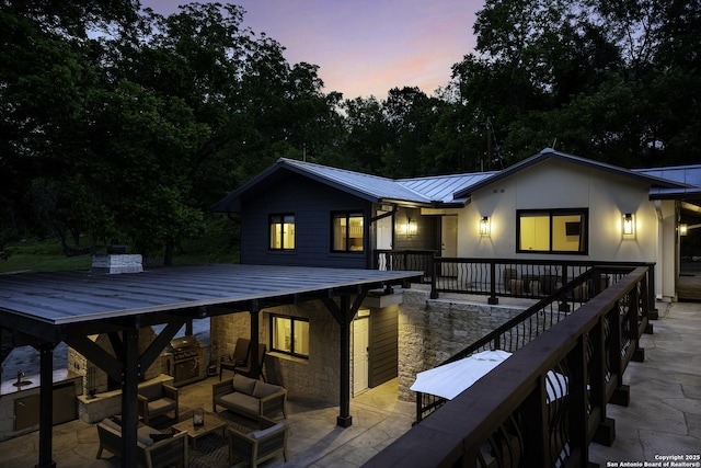 back house at dusk featuring an outdoor hangout area and a patio area