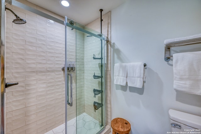 bathroom with toilet and a shower with shower door