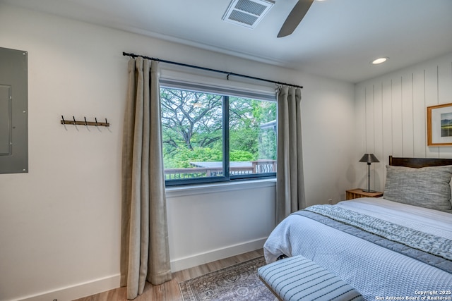 bedroom featuring electric panel, ceiling fan, and light wood-type flooring