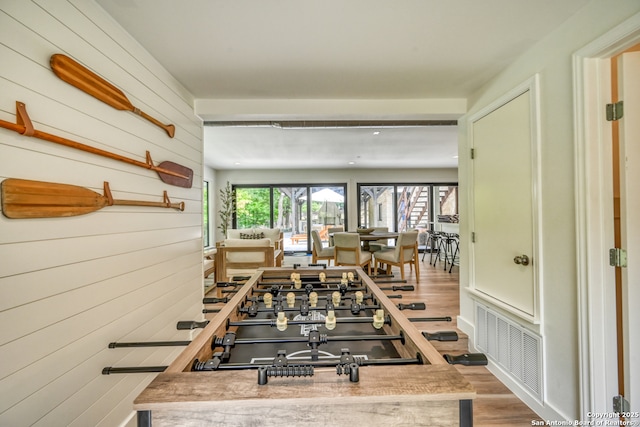 hall with hardwood / wood-style flooring and wood walls