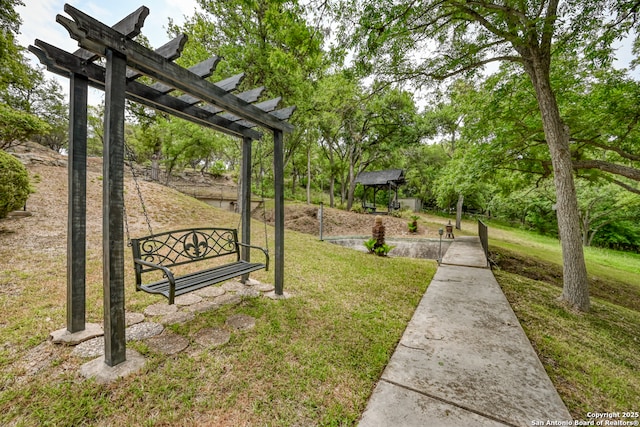 view of community featuring a yard and a pergola