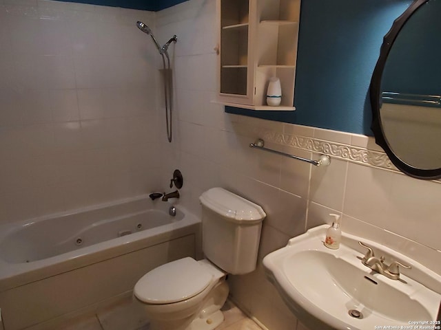 full bathroom with tile walls, sink, toilet, and tiled shower / bath