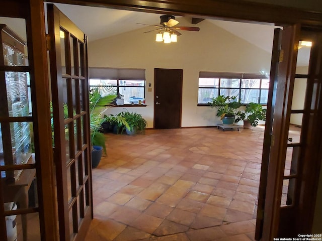 interior space with ceiling fan, plenty of natural light, and lofted ceiling with beams