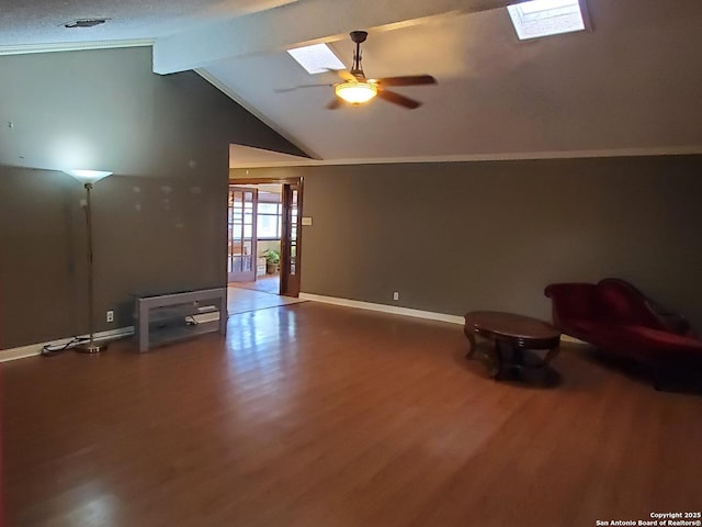 interior space featuring hardwood / wood-style flooring, ceiling fan, and lofted ceiling with skylight