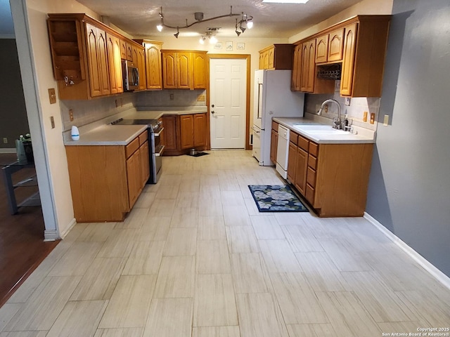 kitchen with light hardwood / wood-style floors, sink, white appliances, and decorative backsplash